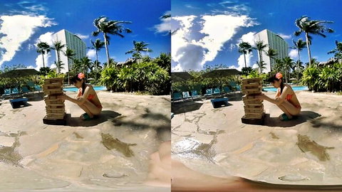 Cute Asian teen with small tits in red bikini stacks Jenga blocks on sandy pool deck outdoors