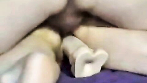 Closeup of woman's pale ass with white heart-shaped butt plug inserted in tight asshole