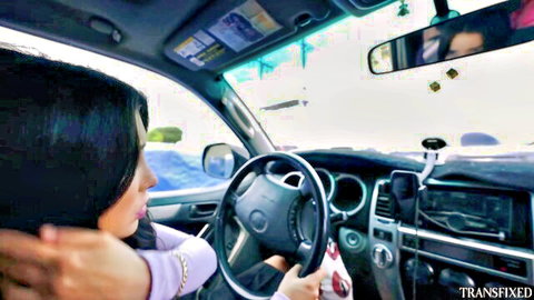 Trans woman driving car in pink top, side profile tease from Transfixed studio