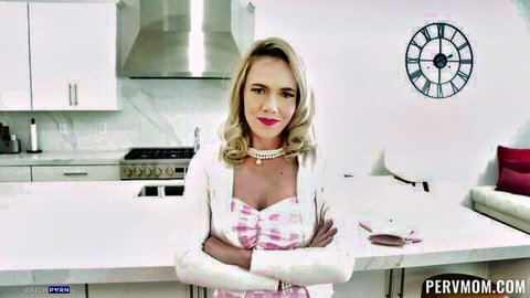 Blonde MILF Rebel Rhyder in pink checkered dress, arms crossed in kitchen