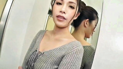 Sexy Asian babe teases with deep cleavage in lace-up gray sweater mirror selfie