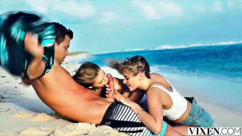 Two blondes suck muscular stud's big cock on sunny beach threesome.