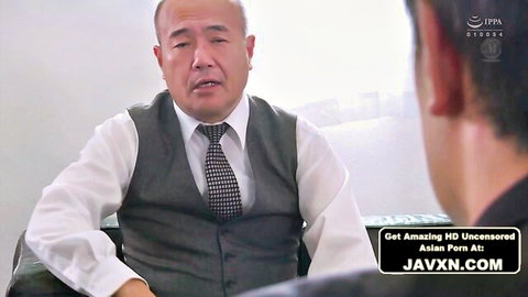 Bald Japanese boss in gray vest tie and white shirt faces young man at office desk in JAV porn