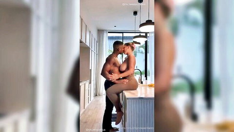 Muscular black stud passionately kisses topless big tits white babe on kitchen counter