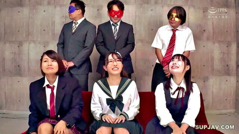 Japanese schoolgirls in sailor uniforms pose with masked suited businessmen