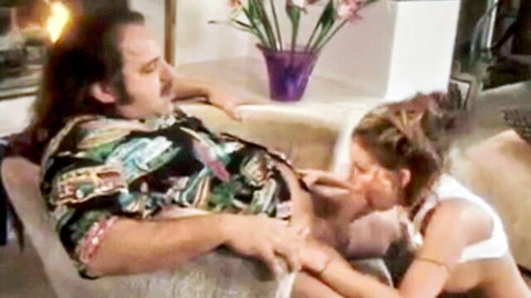 Retro blowjob scene with long-haired man in Hawaiian shirt and blonde woman in white lingerie
