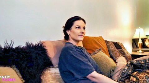Mandy Flores as seductive mom sitting on couch in casual t-shirt