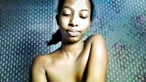 Ebony woman topless, seductive pose with medium breasts