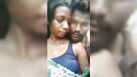 Blurry intimate selfie of young South Asian couple nuzzling faces with her cleavage in blue top