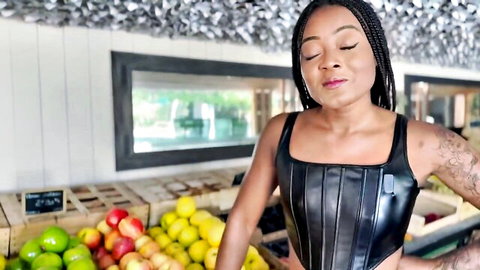 Sexy ebony babe in shiny black leather corset posing at apple market
