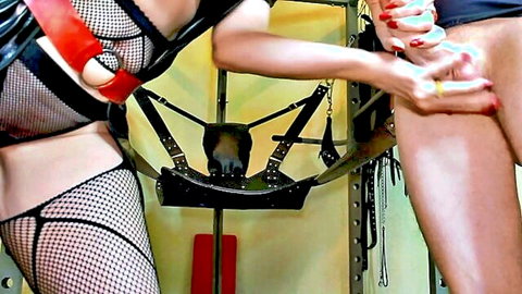 Dominatrix Eva in red harness and latex, teasing with dildo in BDSM femdom scene