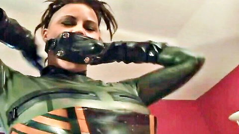 Dominant latex-clad woman with gag in lesbian domination scene