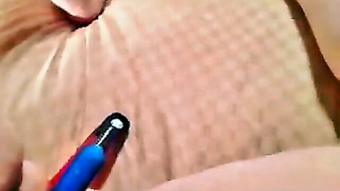 Mature woman lying down as hand draws on her bare abdomen with blue pen