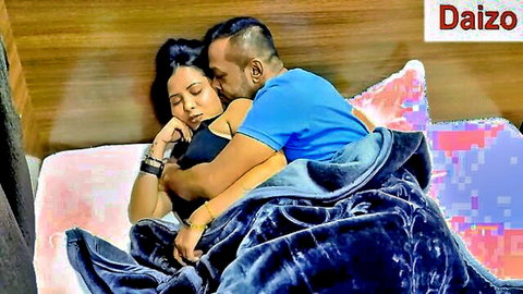 Indian couple spooning intimately on bed with man hugging woman from behind