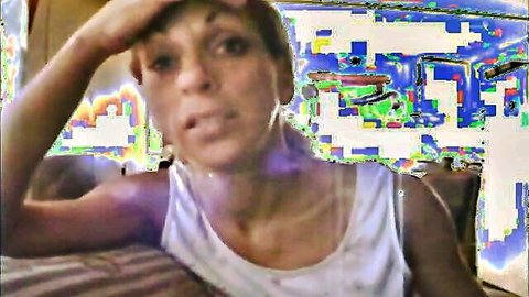 Ebony woman in white tank top yapping on phone with annoyed expression