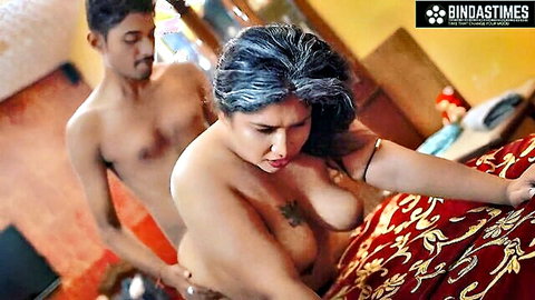 Mature Indian woman with big breasts and gray hair in nude bedroom scene with young man
