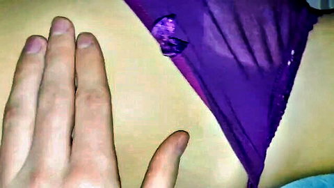 Hands spreading open sexy purple lace panties with bow closeup