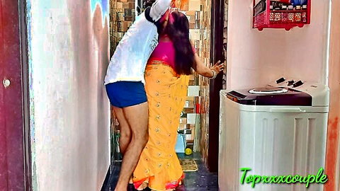 Desi bhabhi in orange saree intimately embraced from behind by lover