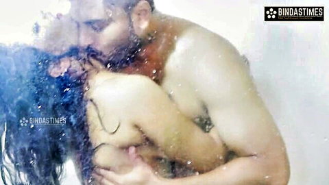 Muscular man squeezes wet tits of long-haired Indian woman in steamy shower kiss