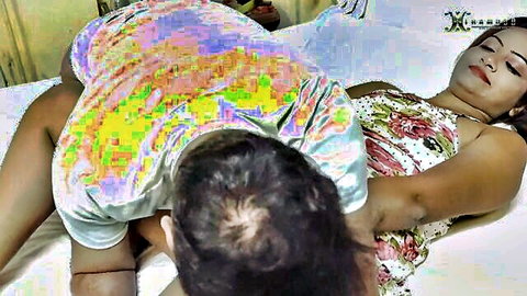 Indian man thrusts into woman's exposed pussy missionary style on bed with floral dress hiked up