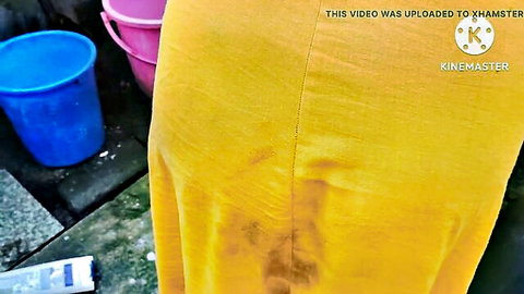 Indian housewife's wet yellow dress clings transparently to her round ass cheeks outdoors