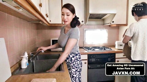 Japanese MILF in tight pants washes dishes at sink while stepson watches her big ass from behind