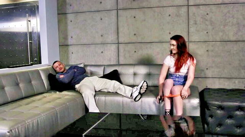 Redhead teen with ankle cuffs sits teasing daddy in tight shorts on couch