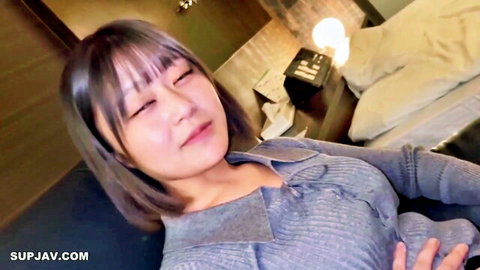 Petite Japanese babe smiling with bouncy natural tits cleavage in hotel sweater