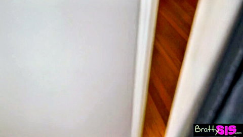 BrattySis.com bedroom corner with white walls, wooden floor and dark curtain