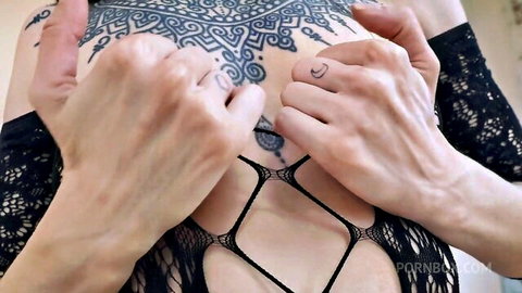 Hands groping tattooed woman's big tits through sheer black fishnet lingerie