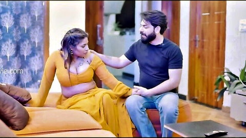 Sexy brunette Indian woman in yellow saree with deep cleavage touched intimately by bearded man on couch