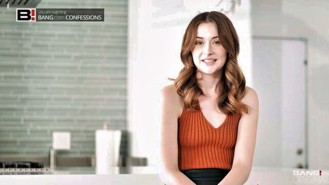 Danni Rivers smiling in low-cut orange tank top, sexy cleavage tease