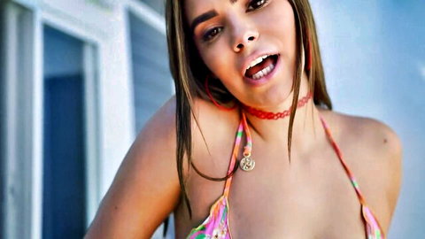 Violet Starr in colorful bikini, smiling seductively outdoors