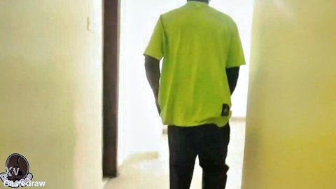 Back view of dark-skinned man in green t-shirt walking in hallway