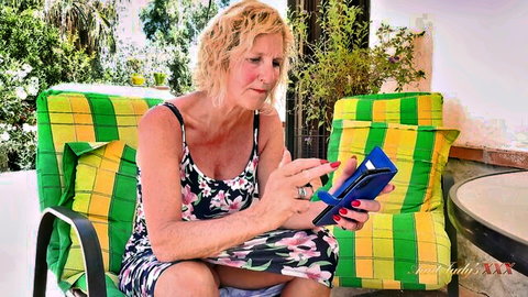 Molly Marcas, British MILF in floral dress holding phone, mature blonde solo
