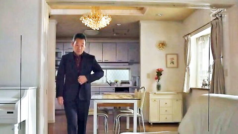 Suited Japanese man walks into modern kitchen dining area in homemade video