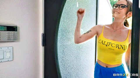 Brunette in yellow California tank top and blue shorts at door, Brazzers tease