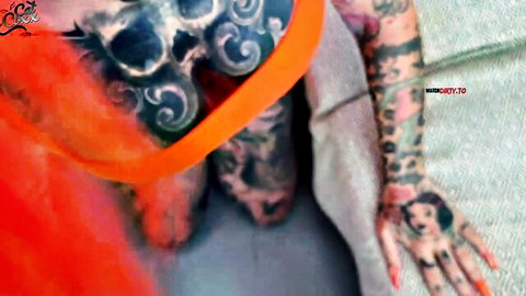 Tattooed model Cat-Coxx in orange lingerie posing seductively
