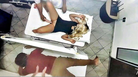 Blonde woman in black lingerie receives intimate massage from male masseur