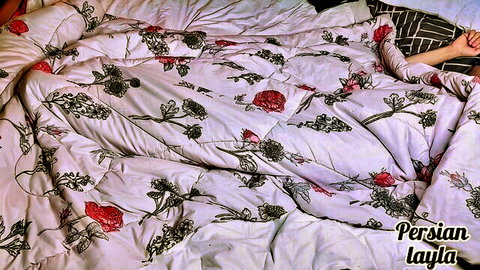Persianlayla in seductive bed pose on floral Persian blanket