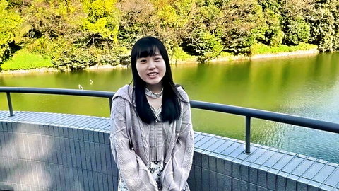 Cute Japanese woman in cozy sweater by lake, smiling with nice body