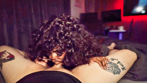 Busty ebony nerd with curly hair intimately massaging tattooed man