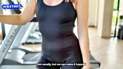 Maya Lis as cute fitness trainer in tight black gym outfit posing in gym