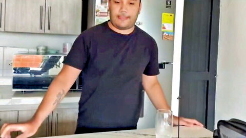 Asian stepdad in black tee smiling in kitchen, teasing horny stepson
