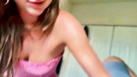 Macy Meadows in pink top, teasing cleavage and smile