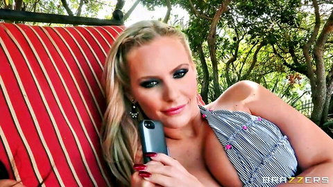 Phoenix Marie in low-cut dress, lounging on swing with Ava Addams in title scene