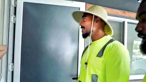 Two muscular Black men in hi-vis yellow shirts and straw hats, gardening setup for steamy gay encounter
