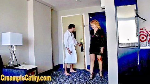 Kinky mature redhead in black dress meets robed man at hotel door