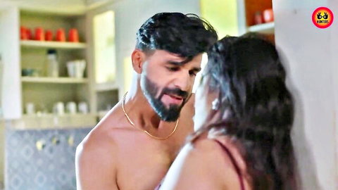Shirtless bearded Indian hunk passionately kisses busty housewife's neck in steamy kitchen embrace