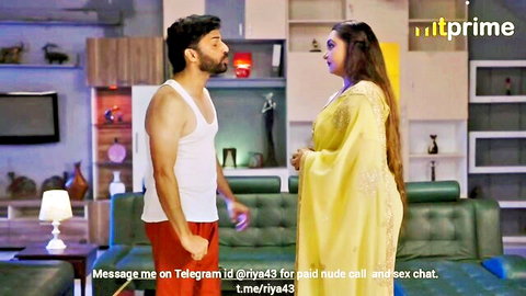 Indian MILF in tight yellow saree stands close to muscular man in white vest and red shorts in living room